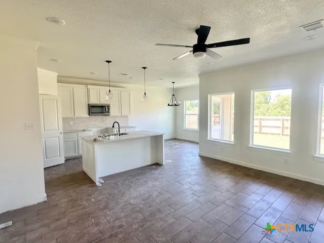a view of kitchen with windows and refrigerator