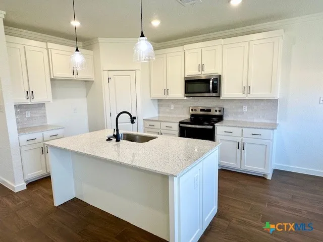 a kitchen with a sink a stove and cabinets