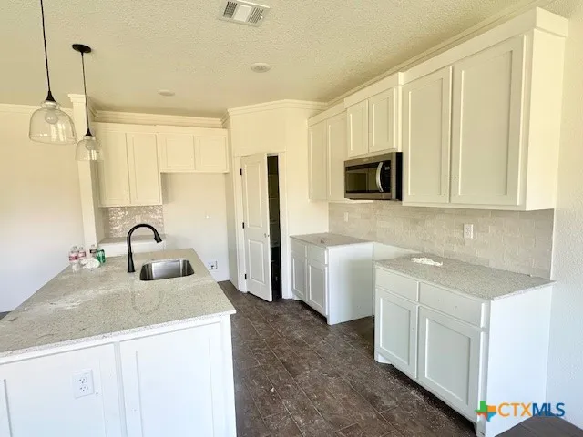 a kitchen with stainless steel appliances granite countertop a sink a stove and a refrigerator