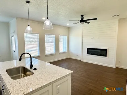 a kitchen with a sink a faucet a chandelier and living room view