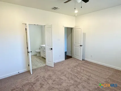 an empty room with a cabinet and a chandelier