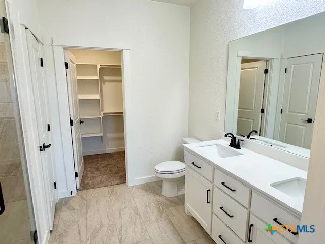 a bathroom with a sink a toilet and shower