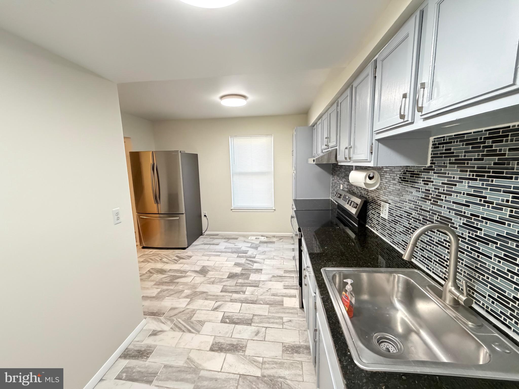 6427 Old Scotts Court Springfield, VA 22152 - Photo 4 of 27 a kitchen with granite countertop a sink a stove and a refrigerator