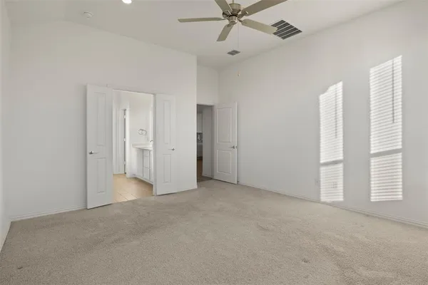 an empty room with windows and fan