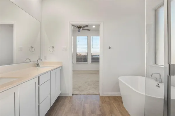 a bathroom with a tub sink and mirror