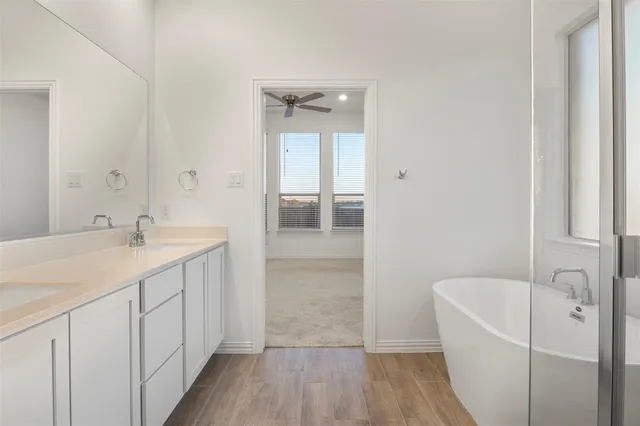 a bathroom with a tub sink and mirror
