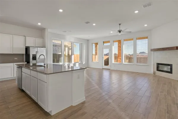 a kitchen with stainless steel appliances granite countertop a stove and a large window