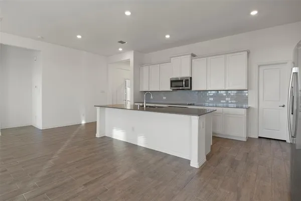 a kitchen with stainless steel appliances granite countertop a white cabinets a sink and dishwasher