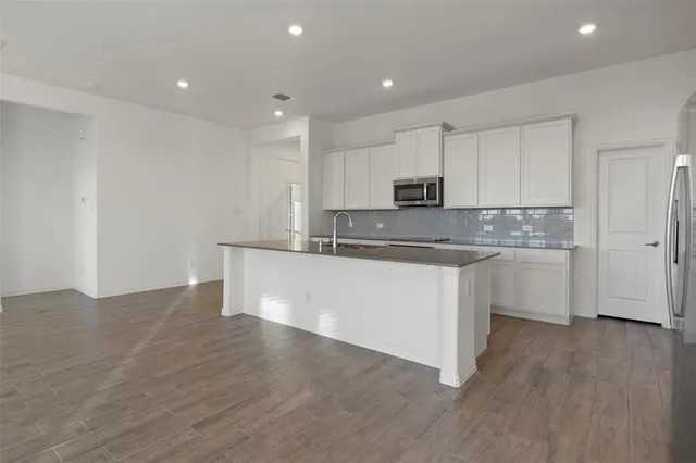 a kitchen with stainless steel appliances granite countertop a white cabinets a sink and dishwasher