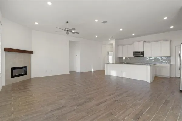 a view of kitchen with kitchen island wooden floor center island and stainless steel appliances