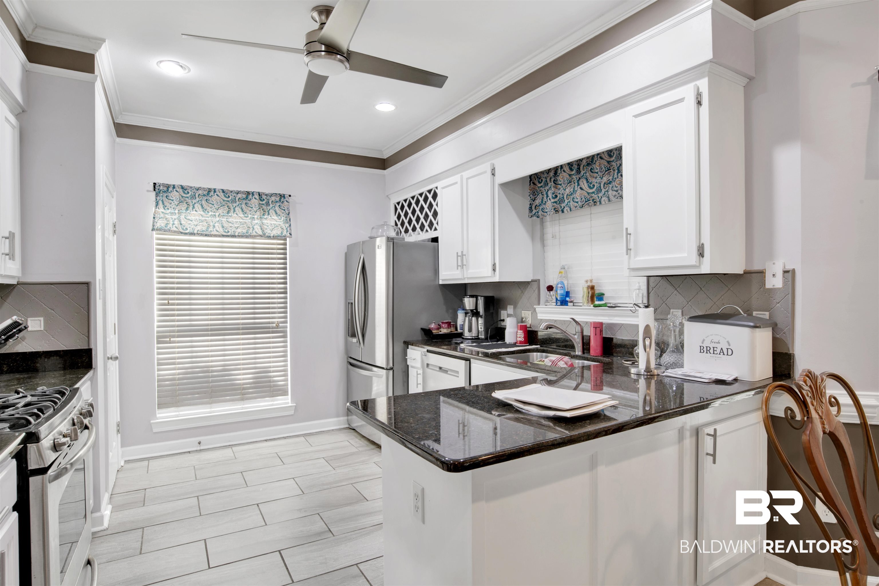 445 Wedgefield Drive South Mobile, AL 36608 - Photo 12 of 36 Kitchen featuring sink, kitchen peninsula, ceiling fan, white gas stove, and white cabinetry