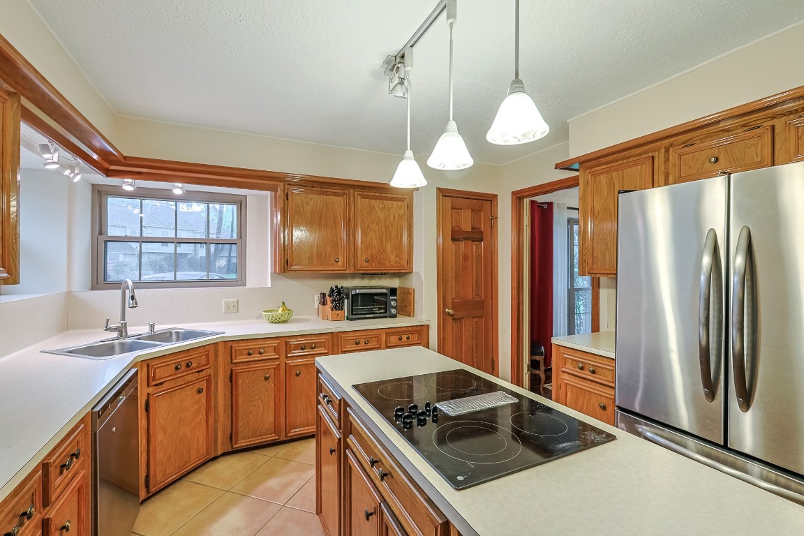 5527 Glenmere Lane Spring, TX 77379 - Photo 15 of 40 a kitchen that has a sink stainless steel appliances a window and a counter top space