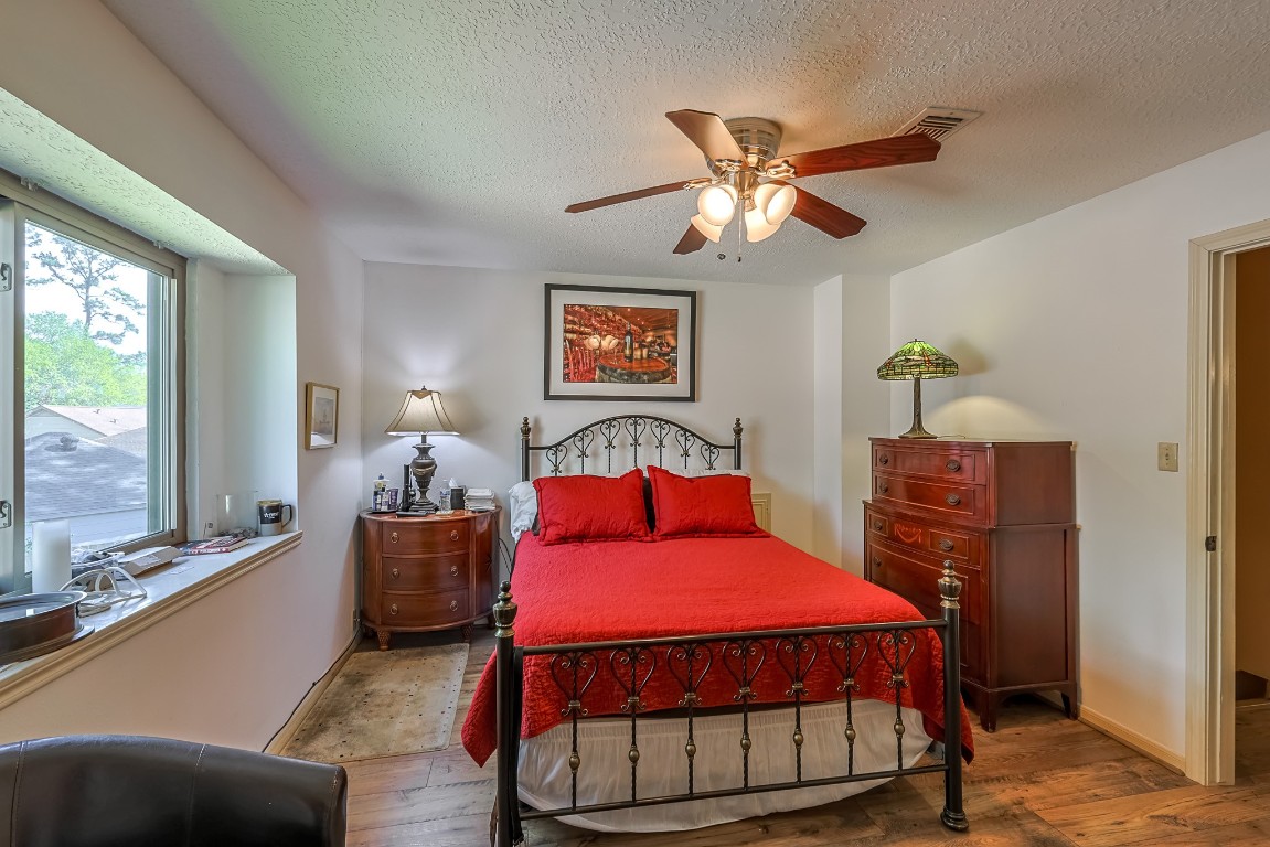 5527 Glenmere Lane Spring, TX 77379 - Photo 34 of 40 a bedroom with a bed and wooden floor