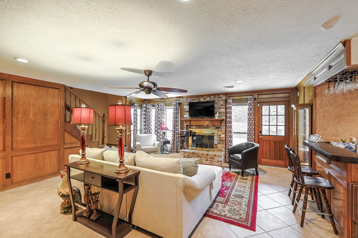 5527 Glenmere Lane Spring, TX 77379 - Photo 6 of 40 a living room with furniture a fireplace and a flat screen tv