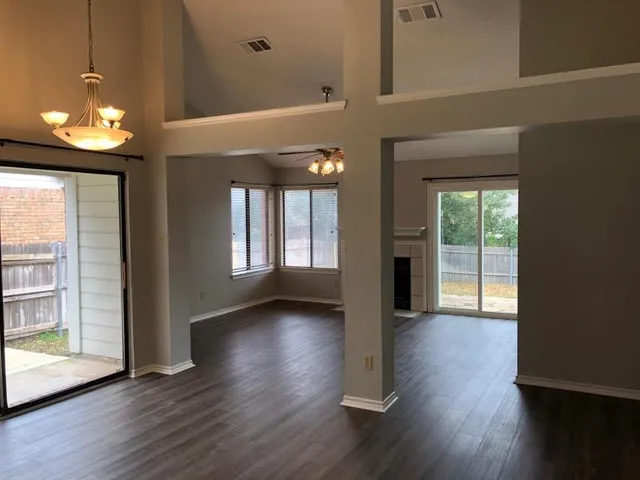 a view of a hallway with wooden floor and a dining room