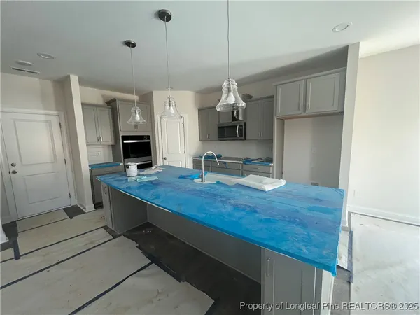 a kitchen with kitchen island a stove and a sink