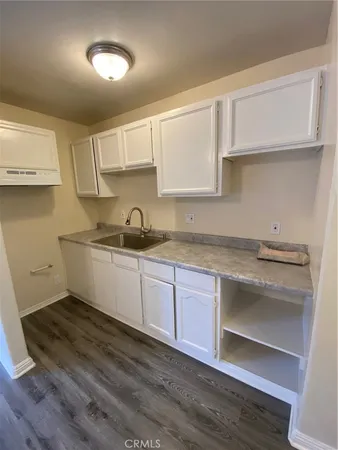 a kitchen with granite countertop a sink cabinets and stainless steel appliances
