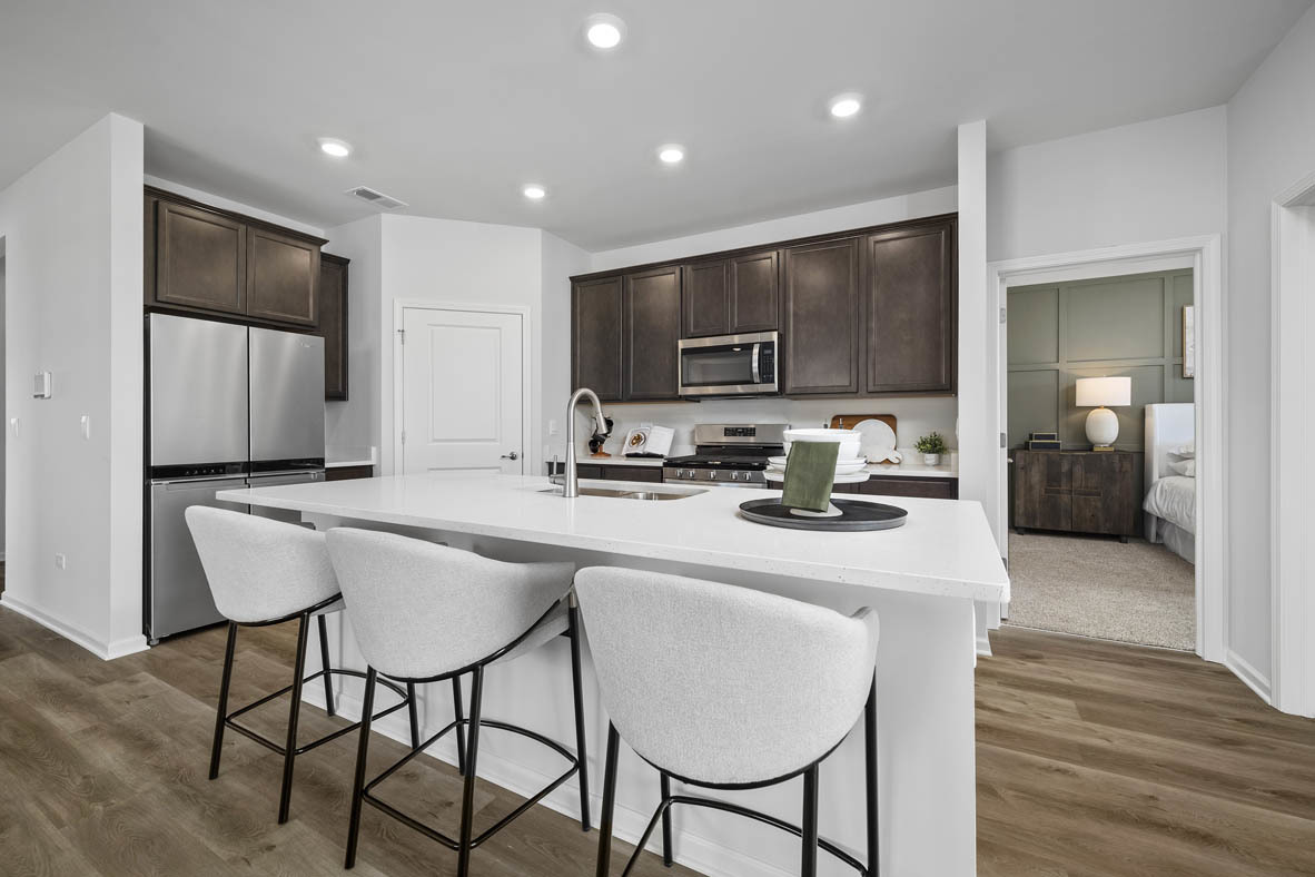 1390 Wild Tulip Circle Bartlett, IL 60103 - Photo 11 of 21 a kitchen with kitchen island granite countertop wooden cabinets and a refrigerator