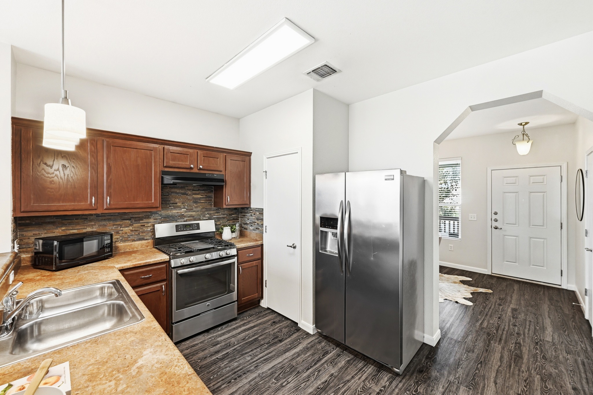2133 Emma Long Street Austin, TX 78723 - Photo 6 of 39 The kitchen features a breakfast bar, stainless-steel appliances, and generous cabinet storage.