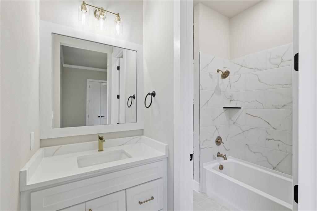 709 Anne Road Van Alstyne, TX 75495 - Photo 14 of 28 Bathroom featuring a white vanity with gold-tone hardware, a rectangular undermount sink, and a white countertop