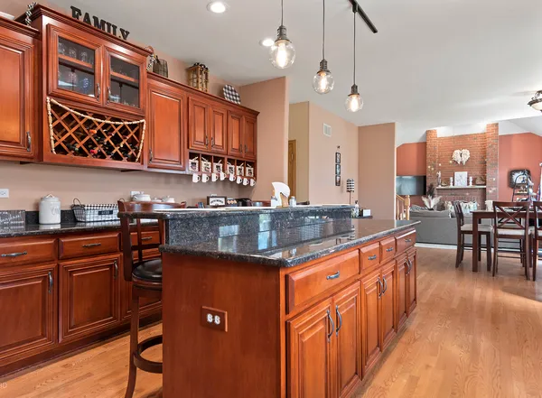a kitchen with stainless steel appliances granite countertop a sink a stove and a wooden cabinets