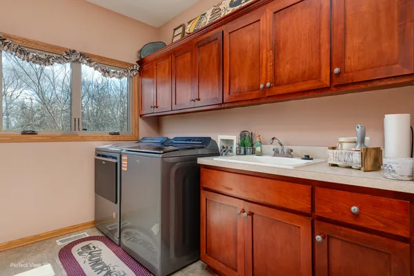 a utility room with granite countertop cabinets washer and dryer
