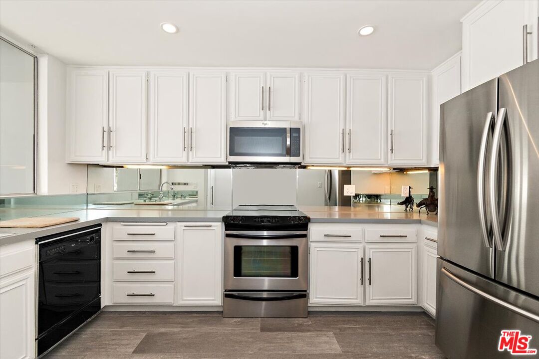 4 Jib Street, Unit 2 Marina del Rey, CA 90292 - Photo 17 of 37 a kitchen with white cabinets and stainless steel appliances
