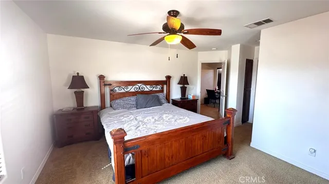 a bedroom with a bed a chandelier and dresser