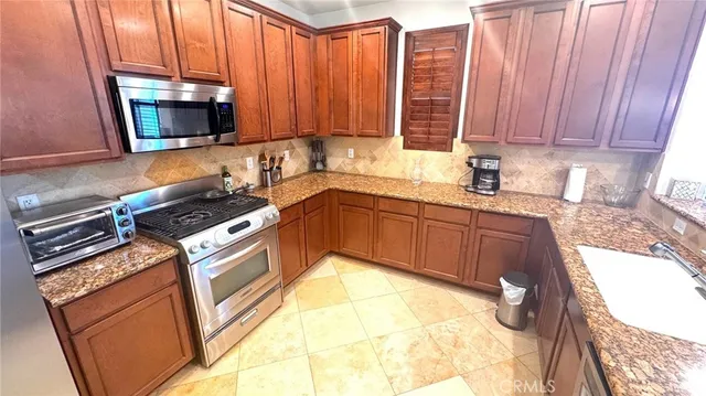 a kitchen with stainless steel appliances granite countertop a stove a sink and a microwave