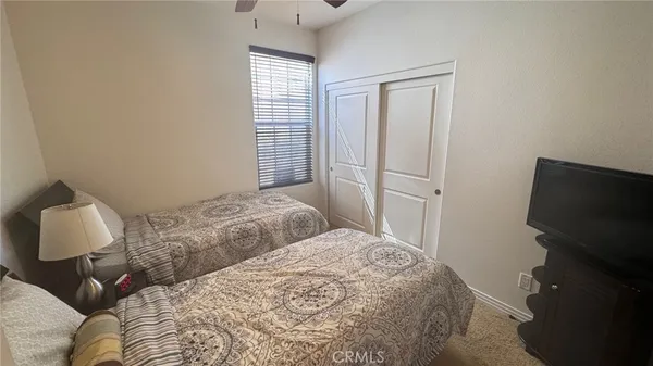 a bedroom with a bed tv and a window