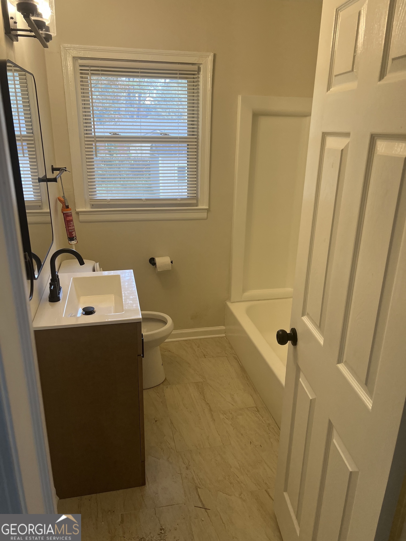 784 Spring Valley Drive Forest Park, GA 30297 - Photo 4 of 12 a bathroom with a tub a sink and a window