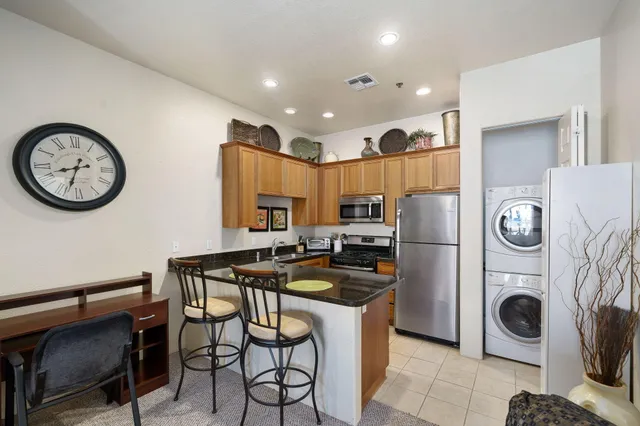a kitchen with a refrigerator and a stove top oven