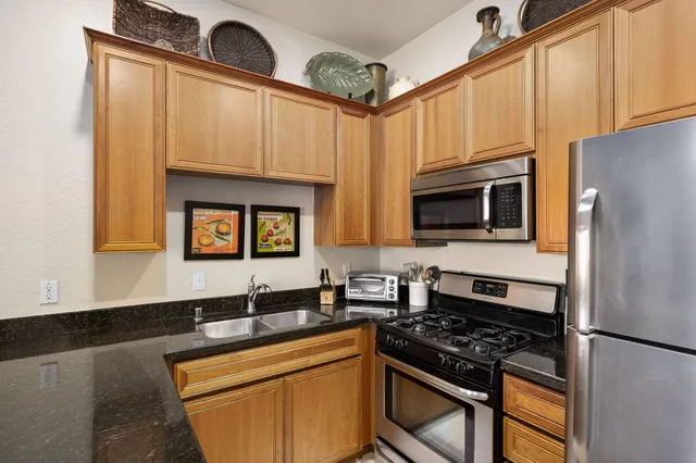 a kitchen with stainless steel appliances a stove a sink and a microwave