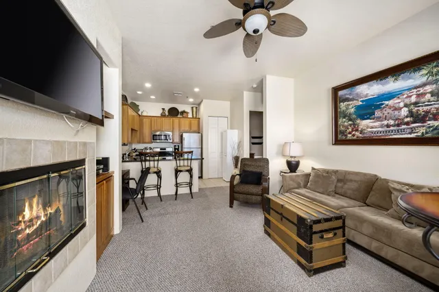 a living room with furniture a fireplace and kitchen view