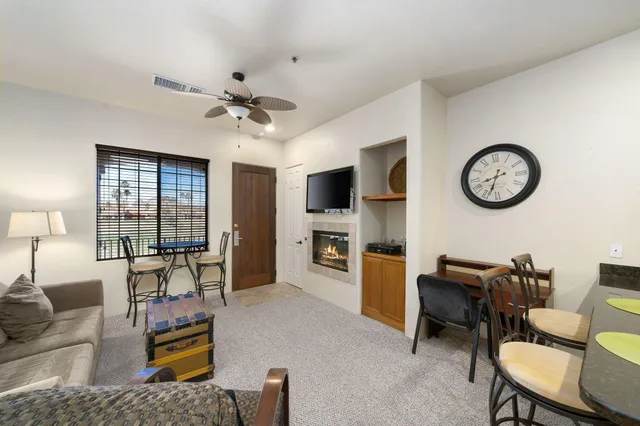 a living room with furniture a flat screen tv and a clock