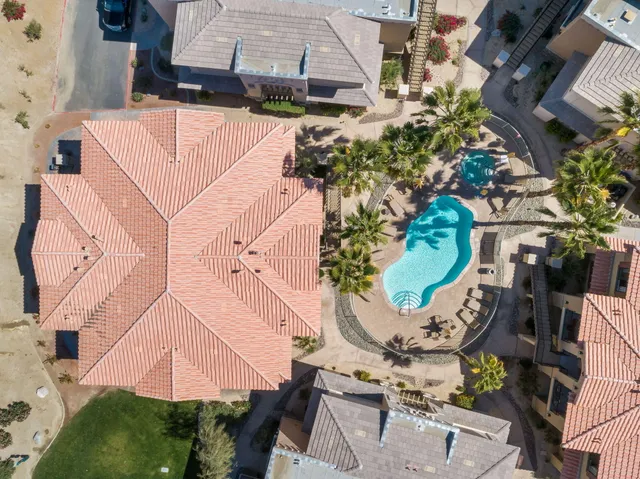 an aerial view of a house with a yard and large trees