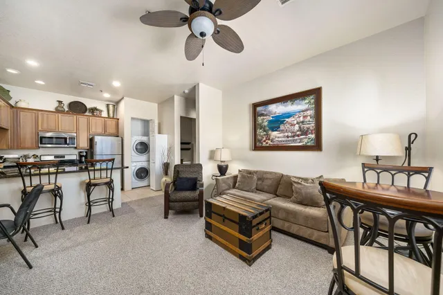 a living room with furniture kitchen view and a chandelier