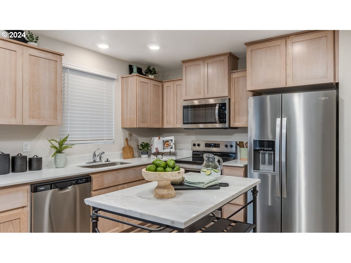 1555 Southeast Pheasant Avenue Gresham, OR 97080 - Photo 11 of 32 a kitchen with a refrigerator a stove a sink cabinets and a dining table