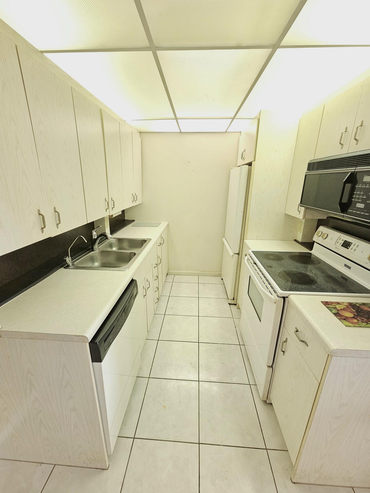 3055 Ainslie Drive, Unit 3055 Boca Raton, FL 33434 - Photo 2 of 26 a kitchen that has a sink and a stove top oven