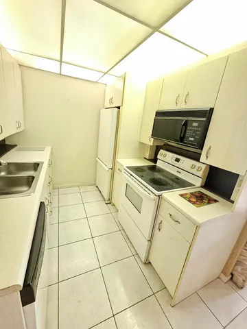 a kitchen with a sink a stove top oven and cabinets