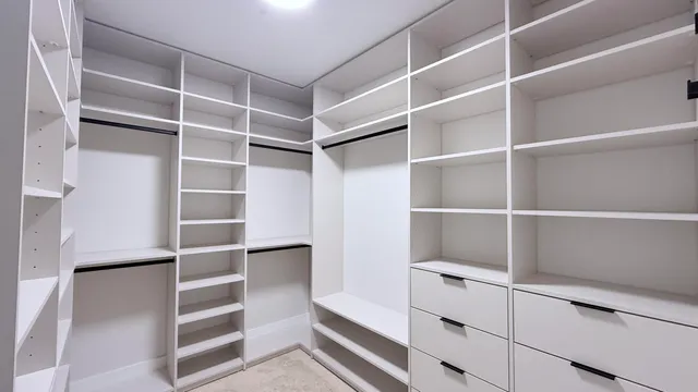 a view of walk in closet with empty racks