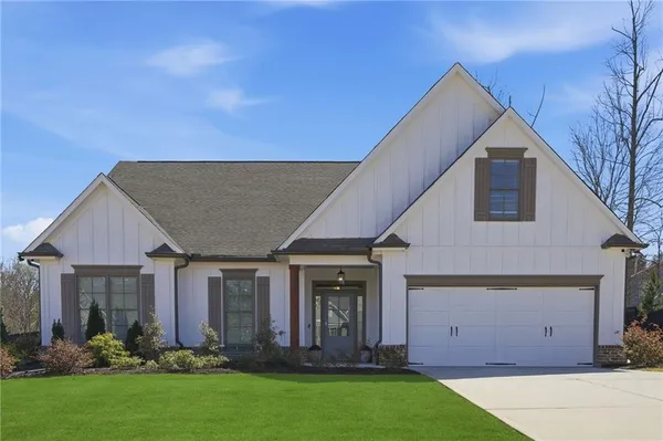 a view of a house with brick walls and a yard with plants