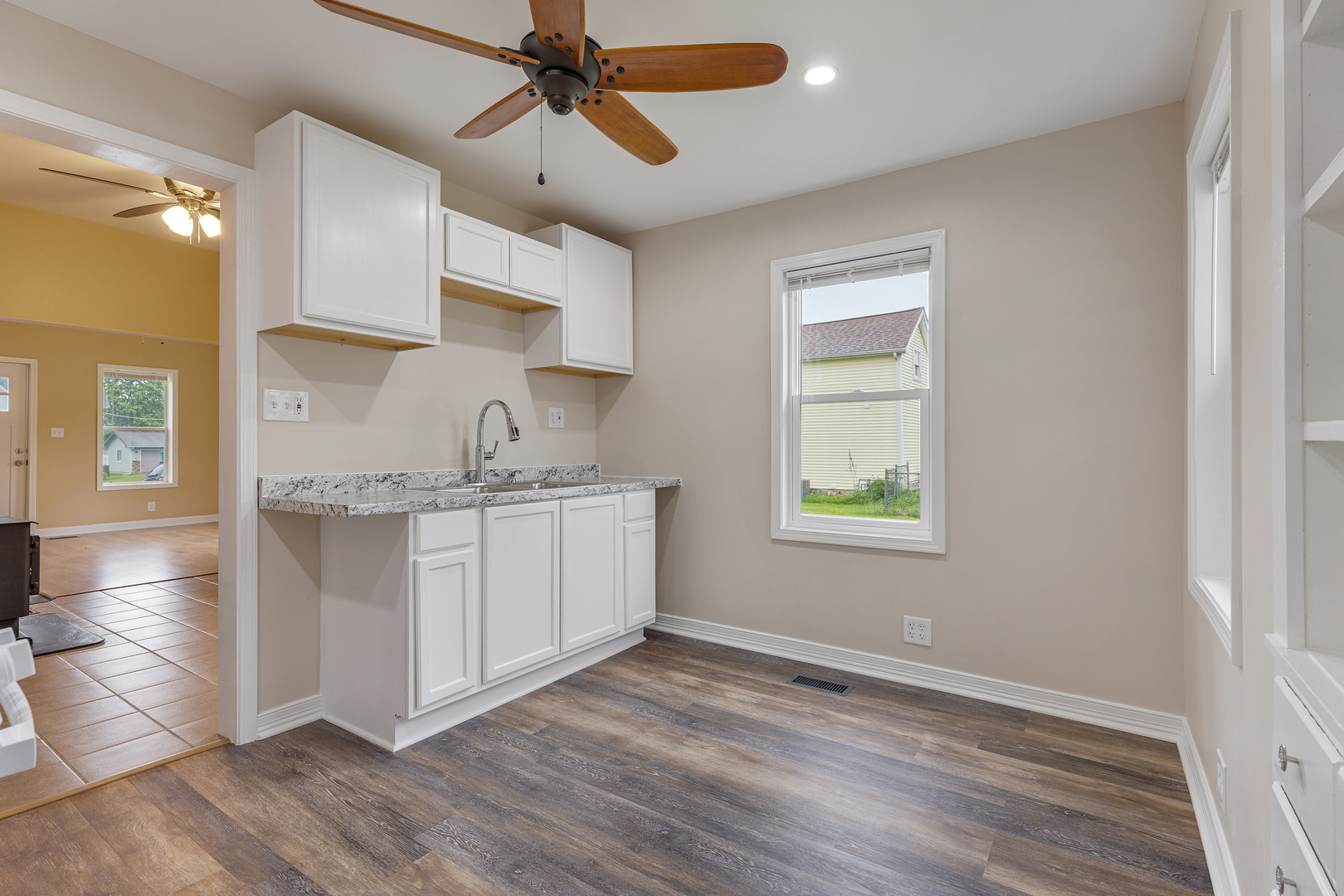 11611 Maple Avenue Hebron, IL 60034 - Photo 11 of 23 a kitchen with stainless steel appliances granite countertop a sink cabinets wooden floor and a window