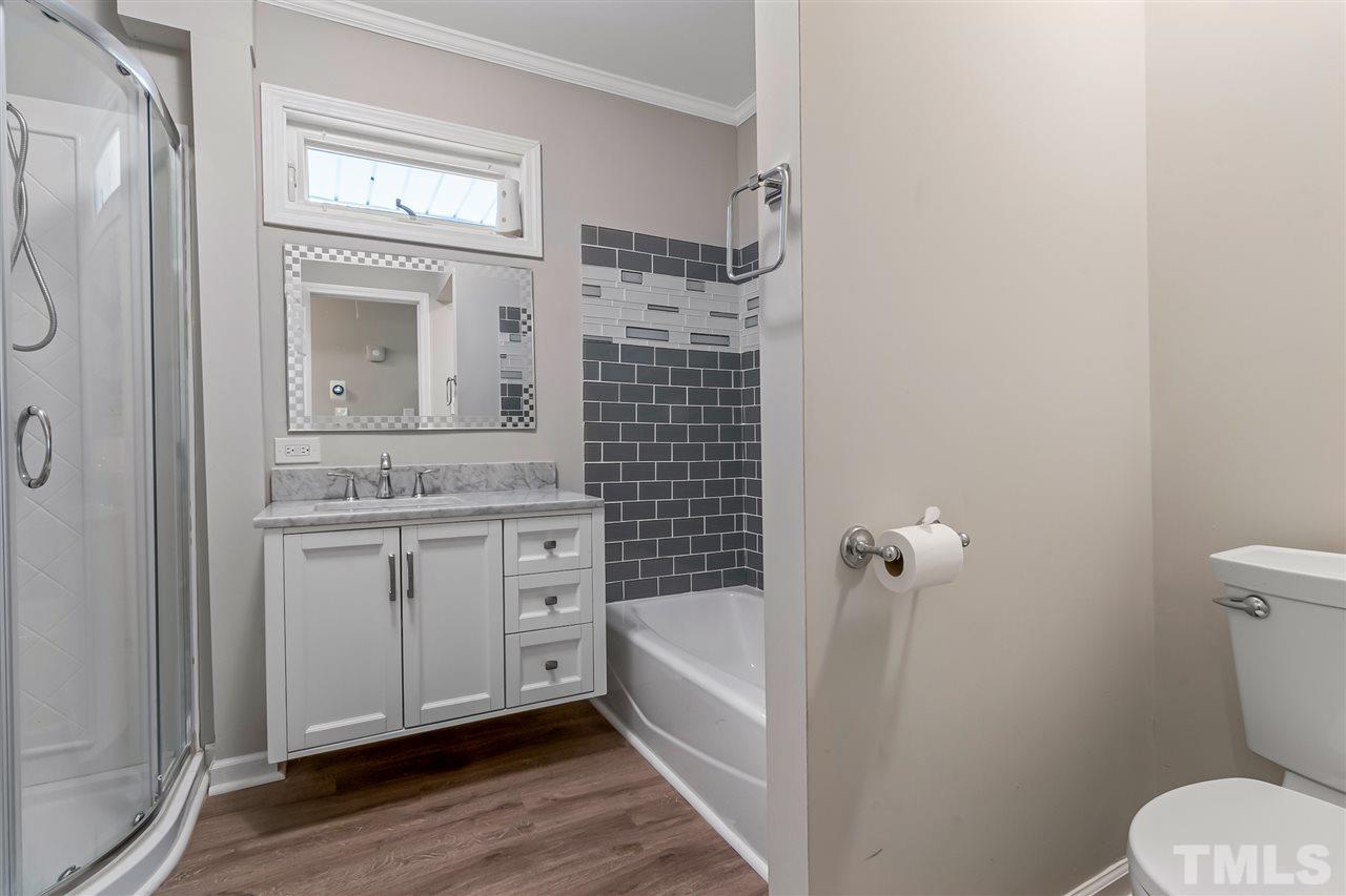 664 Semora Road Roxboro, NC 27573 - Photo 12 of 13 a bathroom with a granite countertop sink toilet and shower