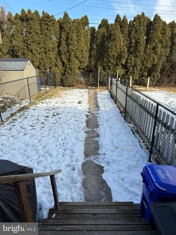 a view of a backyard with wooden fence