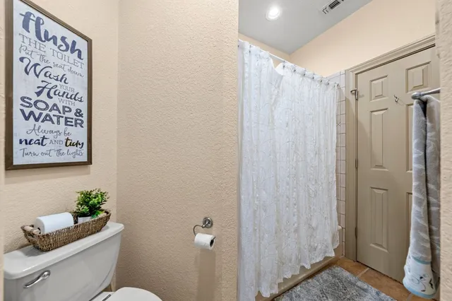 a bathroom with a shower curtain and a toilet