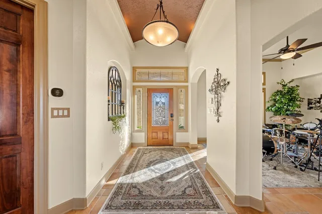 a view of a hallway with windows and chandelier