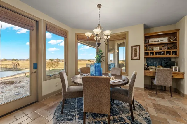 a view of a dining room with furniture large windows and wooden floor