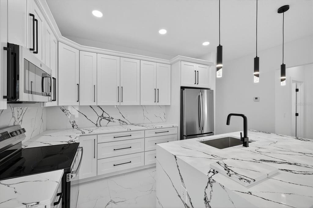 2719 West St John Street Tampa, FL 33607 - Photo 14 of 44 a kitchen with granite countertop a sink a refrigerator and cabinets