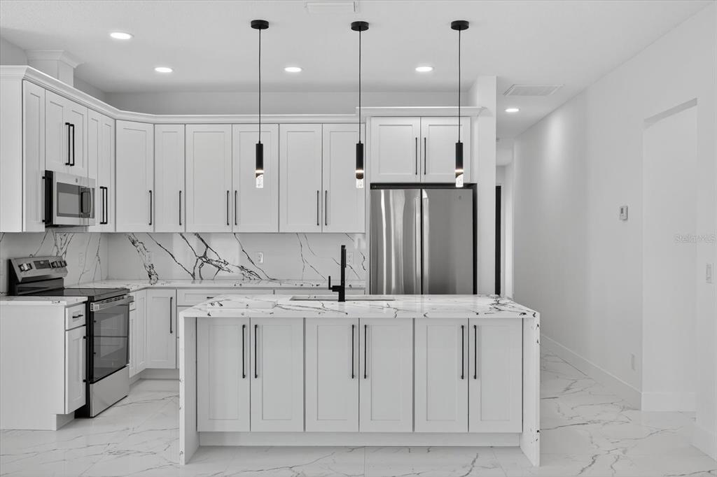 2719 West St John Street Tampa, FL 33607 - Photo 15 of 44 a kitchen with stainless steel appliances granite countertop a sink a stove and a refrigerator